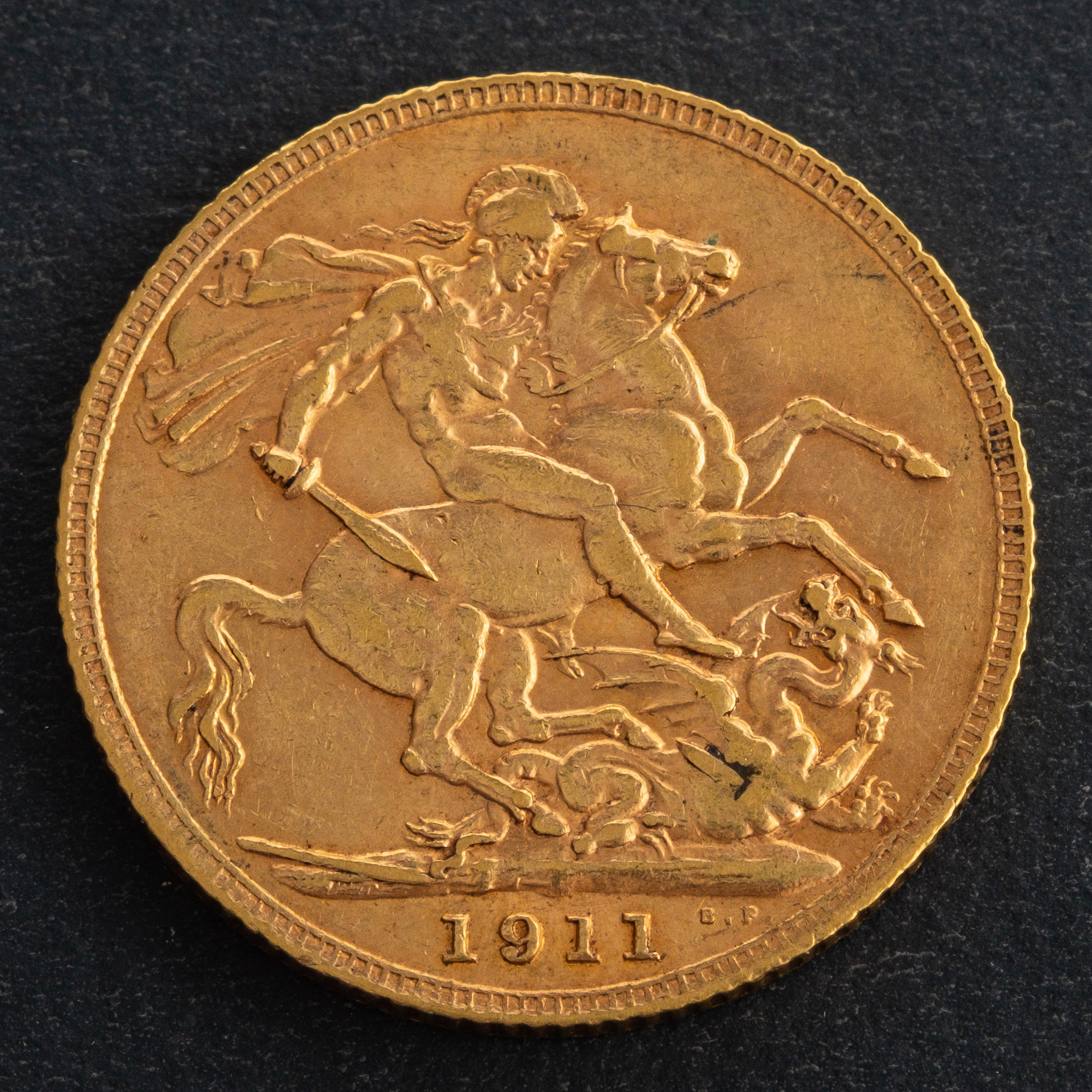 A George V sovereign coin, dated 1911, diameter ca. 21.9mms, total weight ca. 7.9gms.