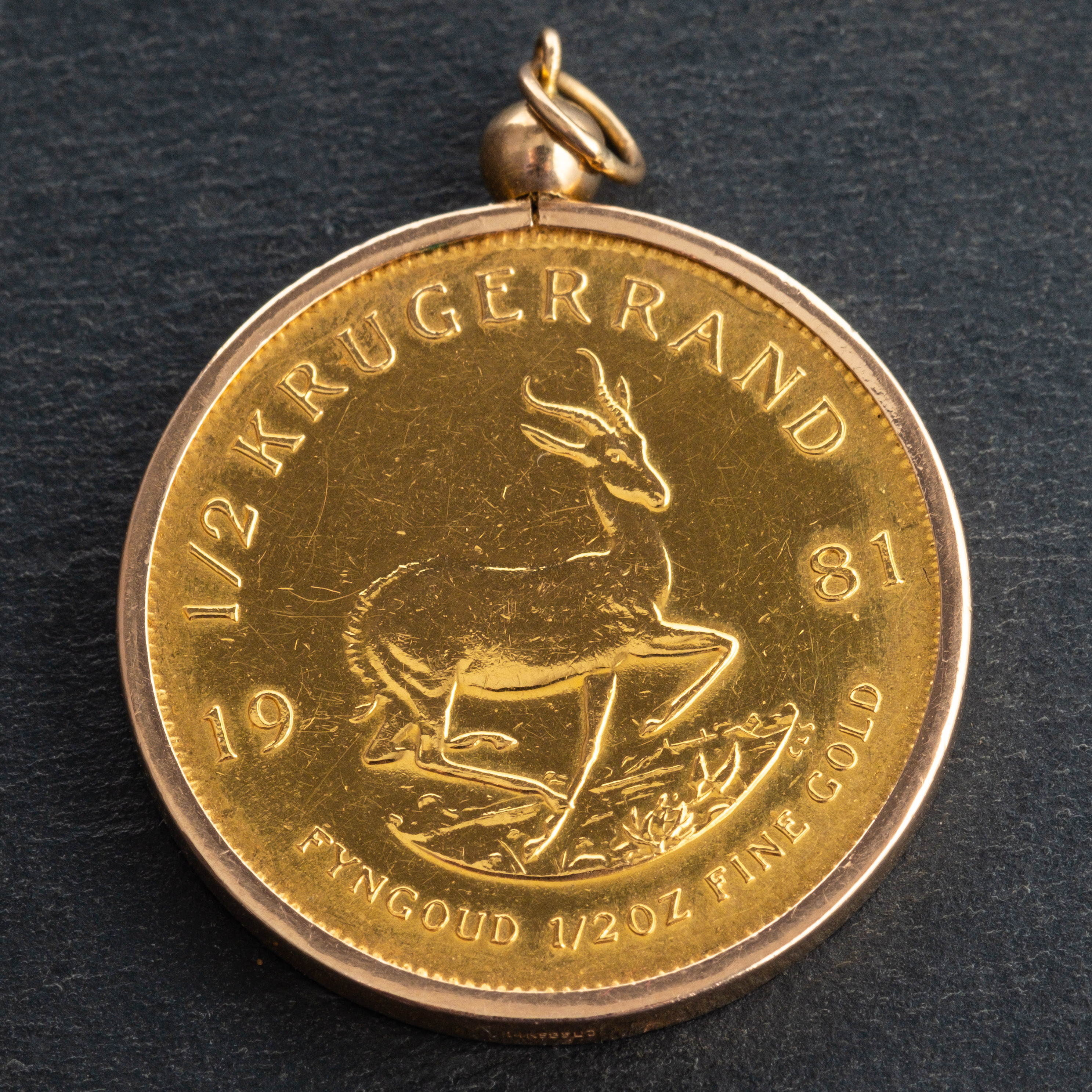 A Half Krugerrand gold coin, dated 1981, mounted as a pendant, total diameter ca. 2.