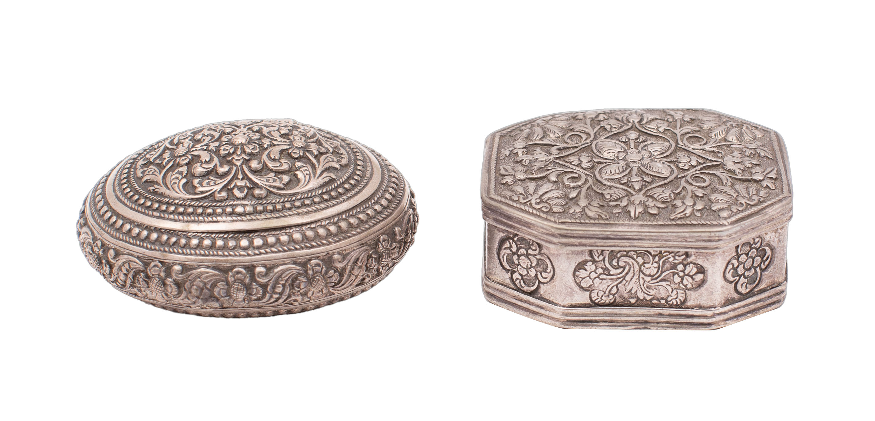 An Indian white metal octagonal pill box the hinged cover embossed with palmettes and scrolling