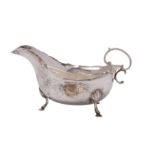 A George VI silver sauceboat, Birmingham 1937 with a wavy edge and scroll handle,