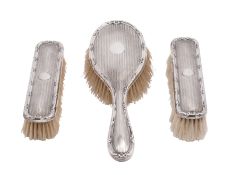 An Edward VII silver backed three-piece dressing table set, makers E.C. and H.M., Birmingham 1909.