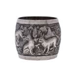 A Burmese silver embossed serviette ring decorated with birds and animals in a naturalistic setting.