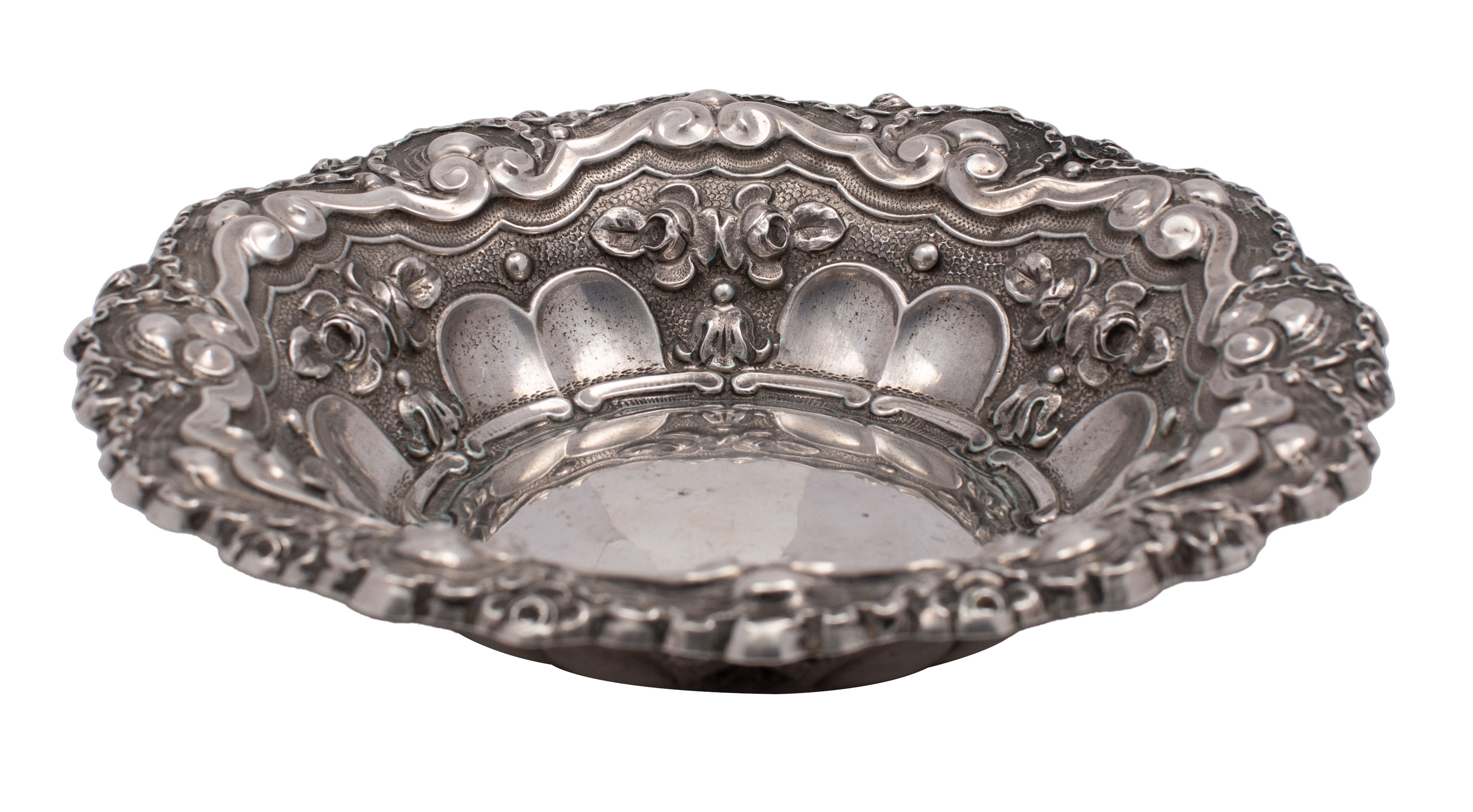 A French silver circular dish with embossed scroll, fluted husk and ribbon decoration,