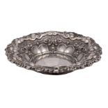 A French silver circular dish with embossed scroll, fluted husk and ribbon decoration,