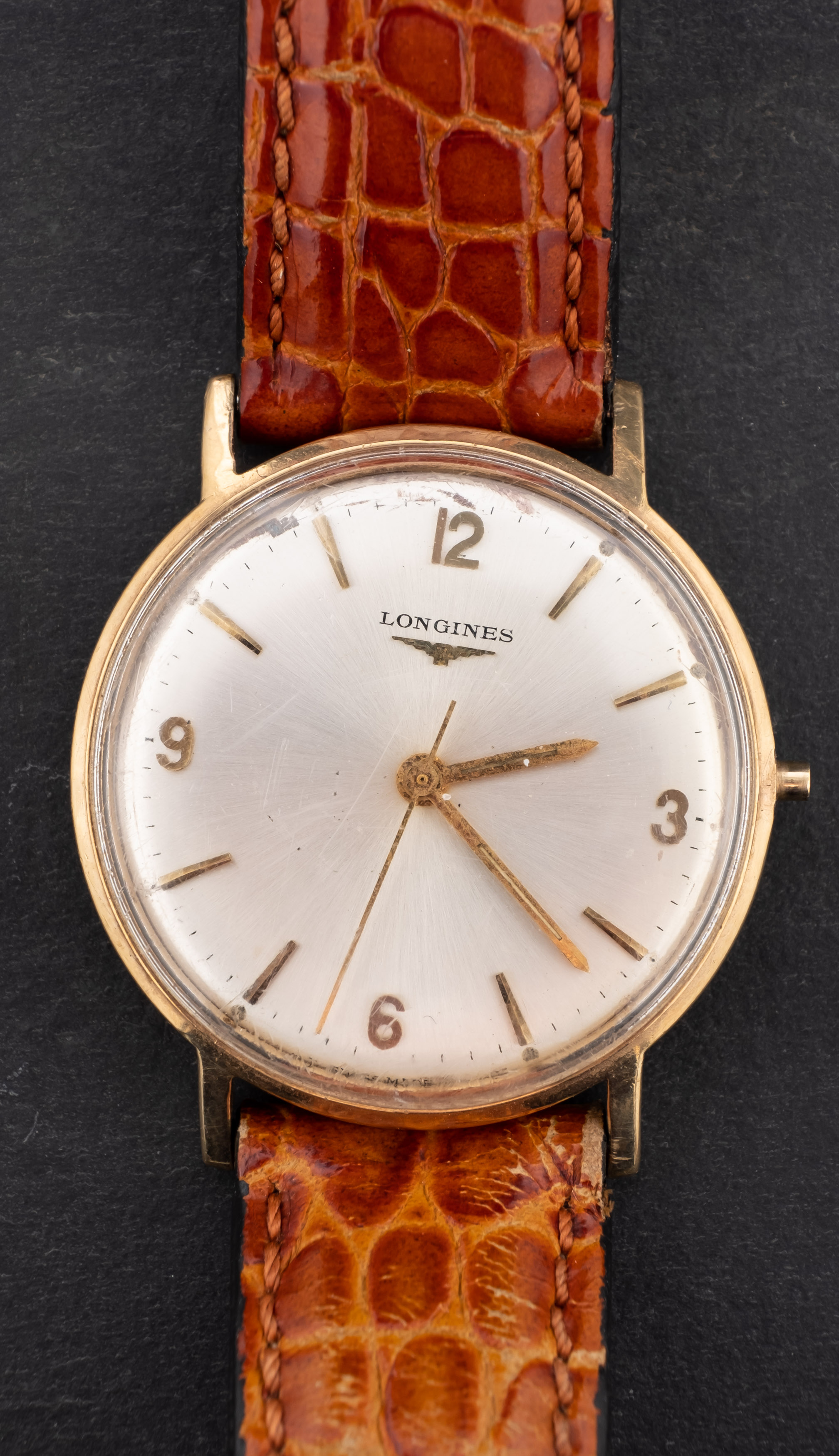 Longines, a gentleman's gold wristwatch the silvered dial with raised Arabic and baton numerals,