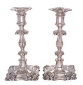 A pair of plated candlesticks in the George II taste with anthemion decoration and knopped stems,