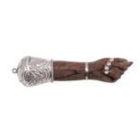 An Indian silver mounted and carved wood pendant forearm the hand with thumb between the index and