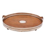 An Edwardian oak and plated oval galleried twin-handled tea tray on four bun feet, 51cm long.