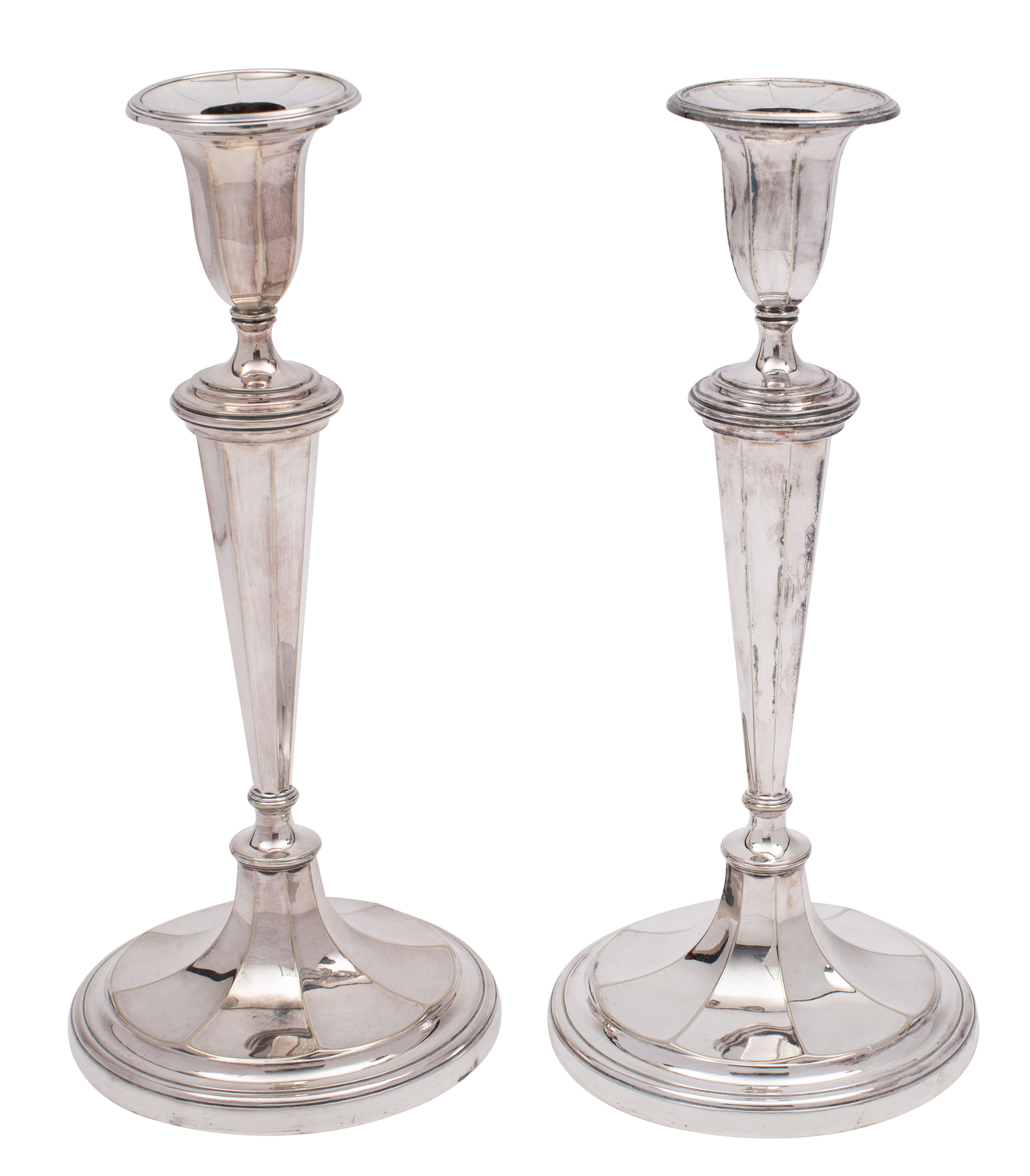 A pair of plated candlesticks with circular fluted sconces,