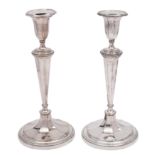 A pair of plated candlesticks with circular fluted sconces,