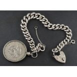 A graduated, curb-link bracelet with a heart-shaped clasp, and a mounted half dollar coin,