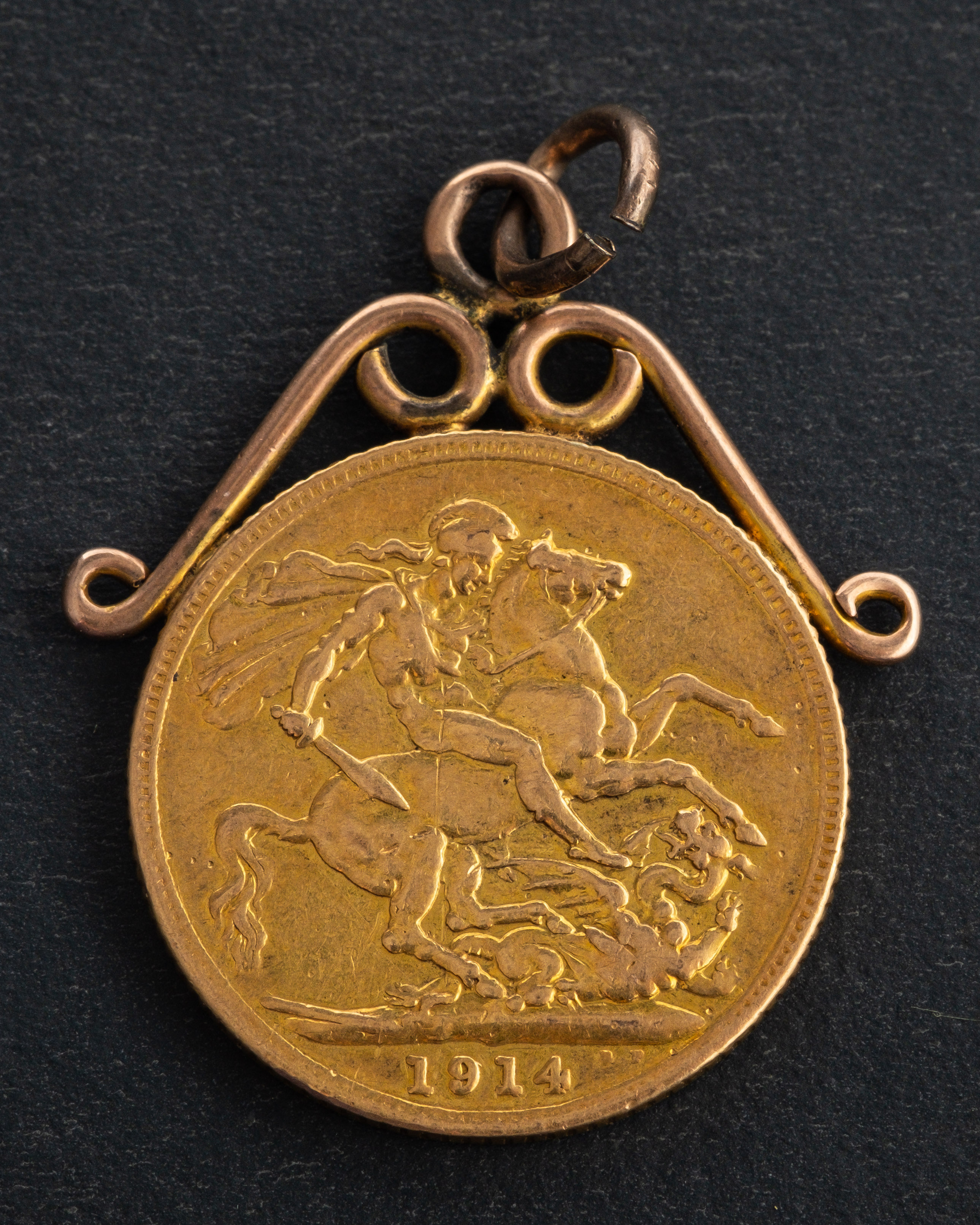 A George V sovereign coin, dated 1914, diameter ca. 22mms, mounted as a pendant, total weight ca.