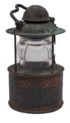 A copper and brass toplight: shaped handle over domed chimney and clear circular lens,