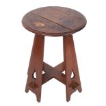 An Arts and Crafts oak circular occasional table on four tapered and splayed standard supports with