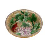 A Chinese cloisonne bowl decorated with colourful flowering stems on a pale yellow ground,