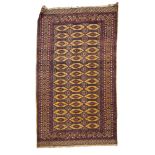 A Turkoman rug, the shaded wine geometric field with three rows of quartered guls,