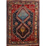 A Quashgai rug, the indigo field with twin hooked hexagonal medallions,