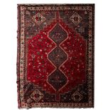 A Shiraz carpet, the red field with a grey triple stepped hexagonal pole medallion, scattered bird,