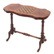 A Victorian walnut and inlaid games table of serpentine outline,