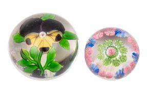 Two French paperweights comprising a Baccarat pansy weight set with a central yellow and purple