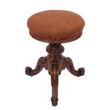 A Victorian carved walnut circular piano stool with an upholstered stuff over seat,