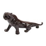 A Japanese patinated bronze model of a tiger with glass eyes,