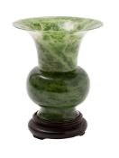 A Chinese jade Gu-form vase the stone of spinach green colour with grey inclusions,