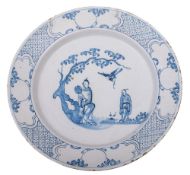 A Bristol blue and white delftware charger painted with oriental figures in a garden,