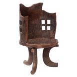 An East African carved hardwood tub chair, probably Guraje people; hewn from a single piece,