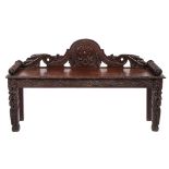 A late Victorian carved oak bench seat, the shaped and domed back with acanthus,