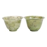 A pair of small Chinese jadeite wine cups the stone of celadon colour with cream and grey