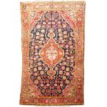 A Joshegan rug, the indigo field with a central brick red shaped lozenge pole medallion,