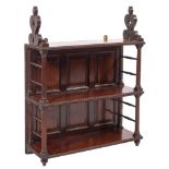 An early 19th Century mahogany three tier hanging bookcase with fret carved stylised foliate