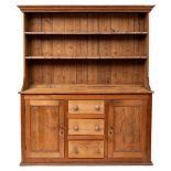 A pine kitchen dresser, early 20th century; the plate rack with moulded cornice above two shelves,