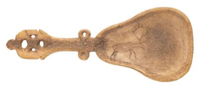 An Inuit carved reindeer horn spoon, the pear-shaped bowl with incised decoration of a reindeer,