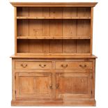 A Victorian pine dresser, late 19th century; the plate rack with cornice above open shelves,