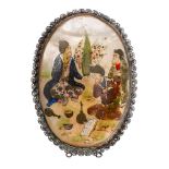 A Persian painted mother-of-pearl oval brooch decorated with three musicians in a garden setting,