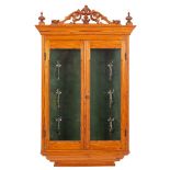 A pine hanging cabinet of small size, with pierced and carved foliate cresting and urn finials,