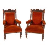 A pair of Victorian carved oak library armchairs, the pediment with carved lion motif,