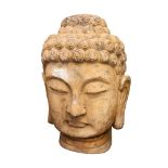 A large carved wood Buddha head, with residue of old paint, 82cm high.