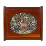 An oval petit point embroidery depiction of a deer in a landscape, in Arts and Crafts style,