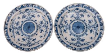 A pair of Dutch blue and white delftware chargers with central bosses each painted with a