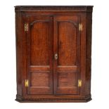 A George III oak hanging corner cabinet,