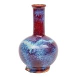 A Chinese flambe bottle vase with globular body and cylindrical neck, covered in a rich ox-blood,