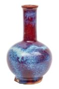 A Chinese flambe bottle vase with globular body and cylindrical neck, covered in a rich ox-blood,
