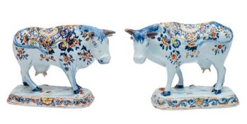 A pair of Dutch delftware cows modelled standing four square, head tilted to one side,