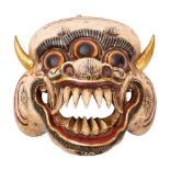 A Nepalese carved and painted wood face mask in the form of a demon, 25cm wide.