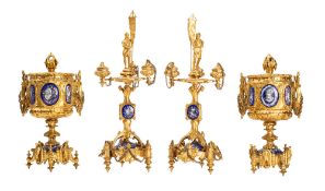 A French gilt metal and enamelled garniture of a pair of three light candelabra and a pair of