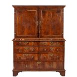 An early 18th Century walnut cabinet on chest, the upper part with a moulded cornice,