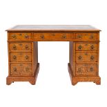 An Edwardian oak pedestal desk in the Gothic manner, the rectangular top with a bevelled edge,